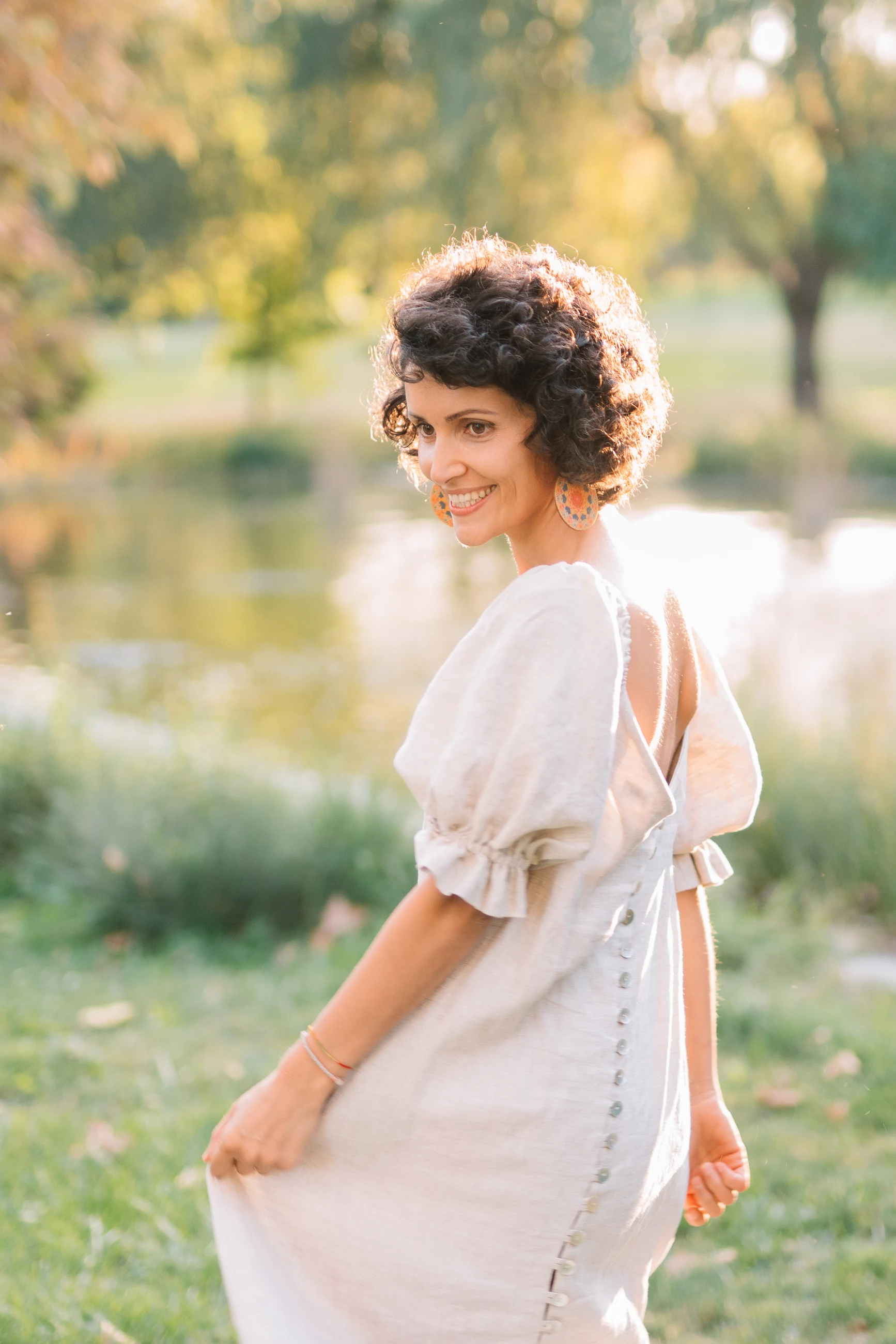 Alexandra Petrache, zâmbind în lumina caldă a unei grădini.